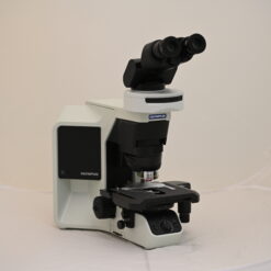 Eine Nahaufnahme der Objektive eines Olympus Mikroskops, die auf dem Revolver angebracht sind. Eines der Objektive ist ein Plan N 10x/0.25.